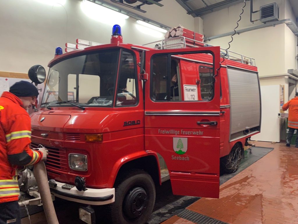 Ein Löschfahrzeug LF 8-TS der Freiwilligen Feuerwehr Seebach. Einige Feuerwehrleute arbeiten.