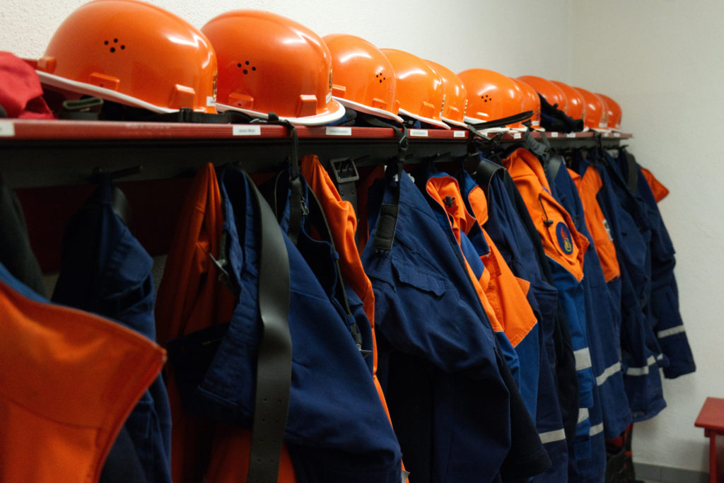 Umkleide der Jugendfeuerwehr Seebach. Mehrere Uniformen auf an einer Reihe Haken.